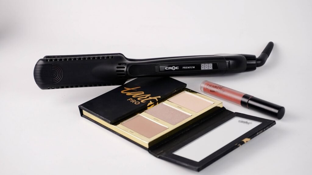 Hair flat iron resting near a makeup palette