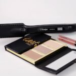 Hair flat iron resting near a makeup palette